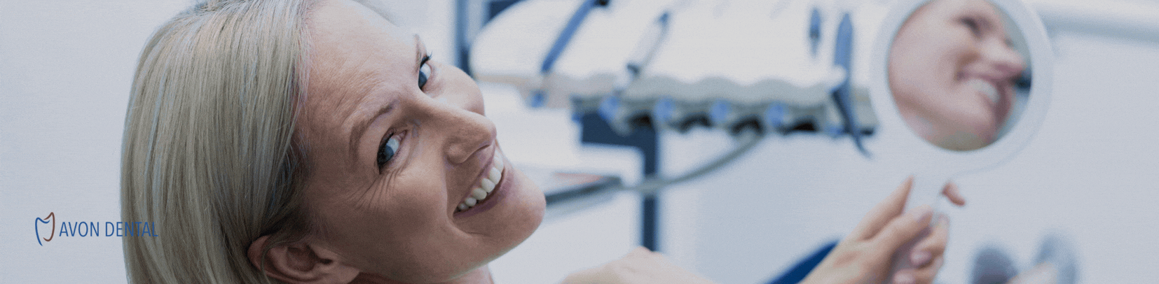 Happy dental patient holding a shade guide during same-day crown appointment at Avon Dental in Ohio.